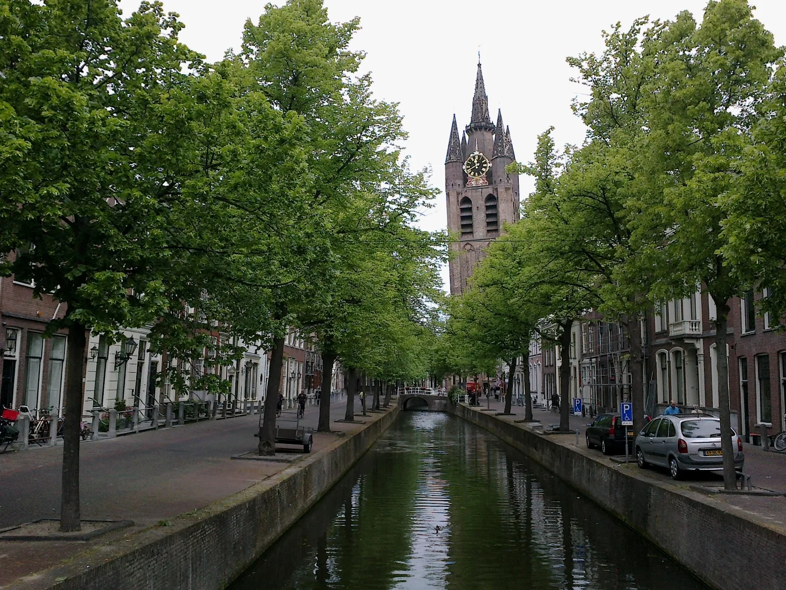 Canal bordé de maisons anciennes et tour penchée de l'Oude Kerk à Delft